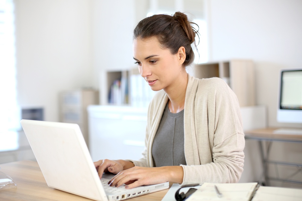 Attractive woman working in office on laptop.jpeg