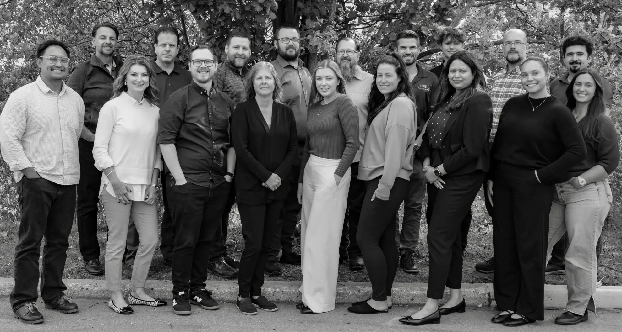 Group photo of 18 adults outdoors in fall setting – professional team or organization portrait