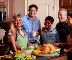 Reis Informatica image of a multigenerational family preparing a holiday meal together in a kitchen.