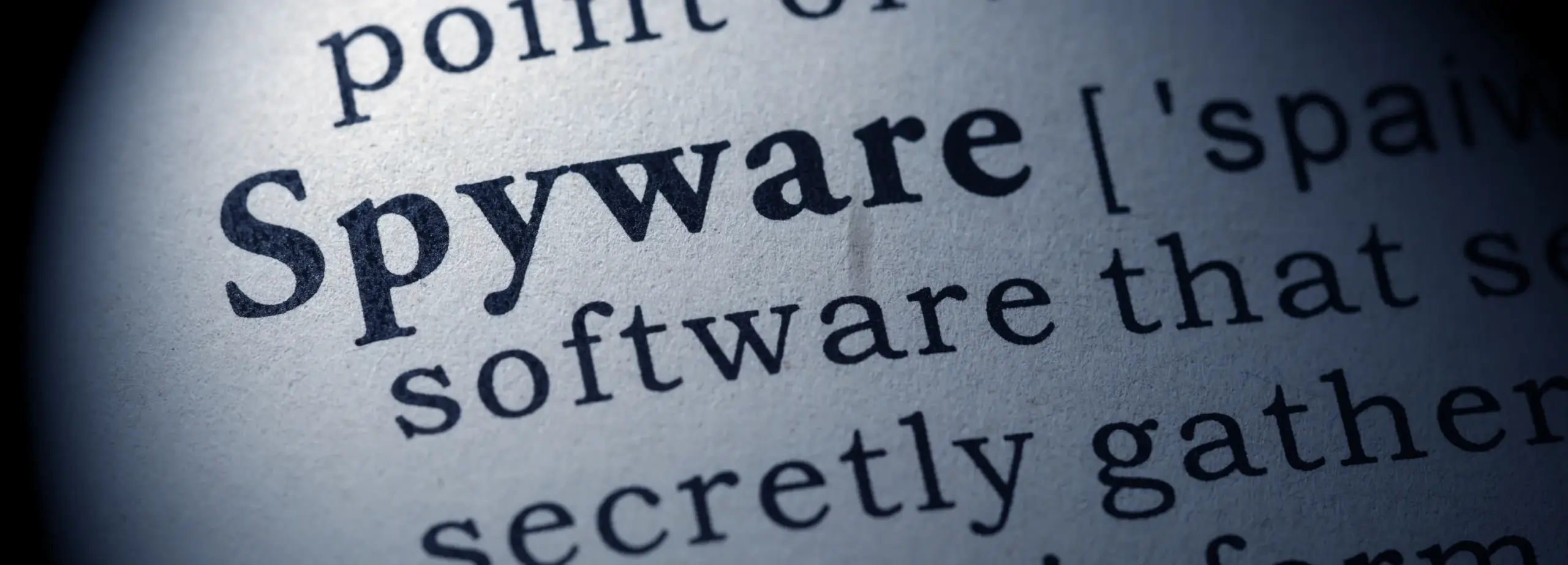Close-up of dictionary page highlighting 'Spyware' definition – cybersecurity and digital privacy concept