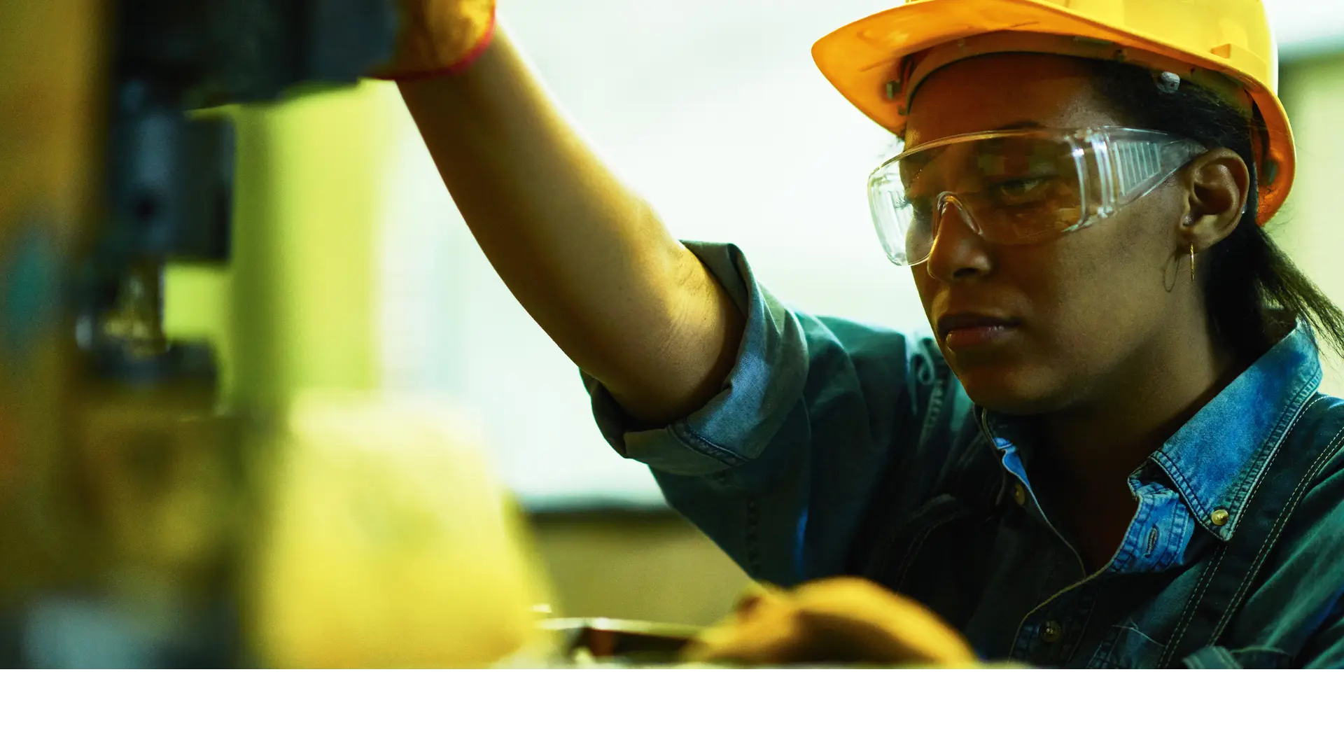 Industrial worker in safety gear inspecting machinery – workplace safety and manufacturing environment